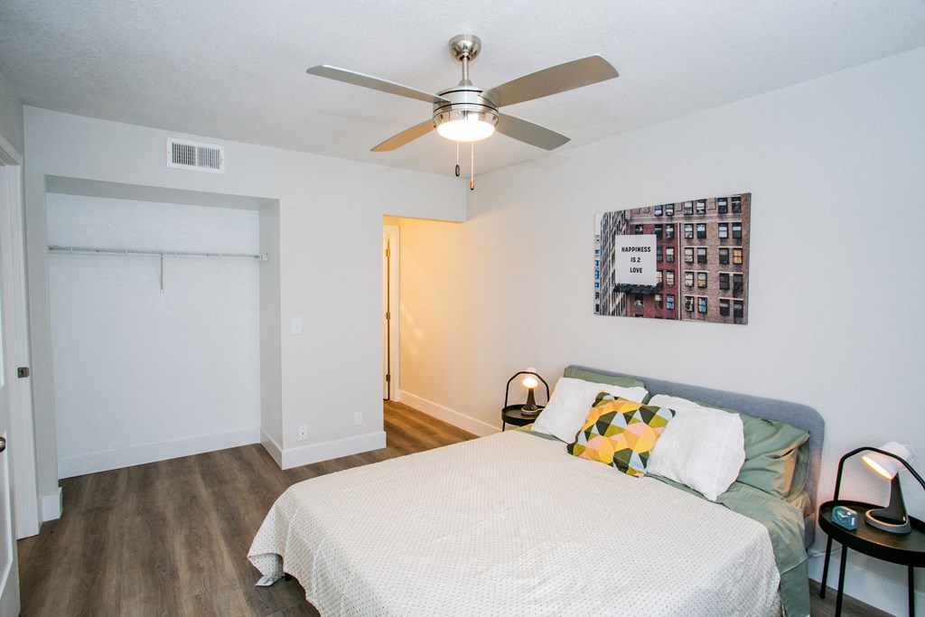 a bedroom with a bed and a ceiling fan