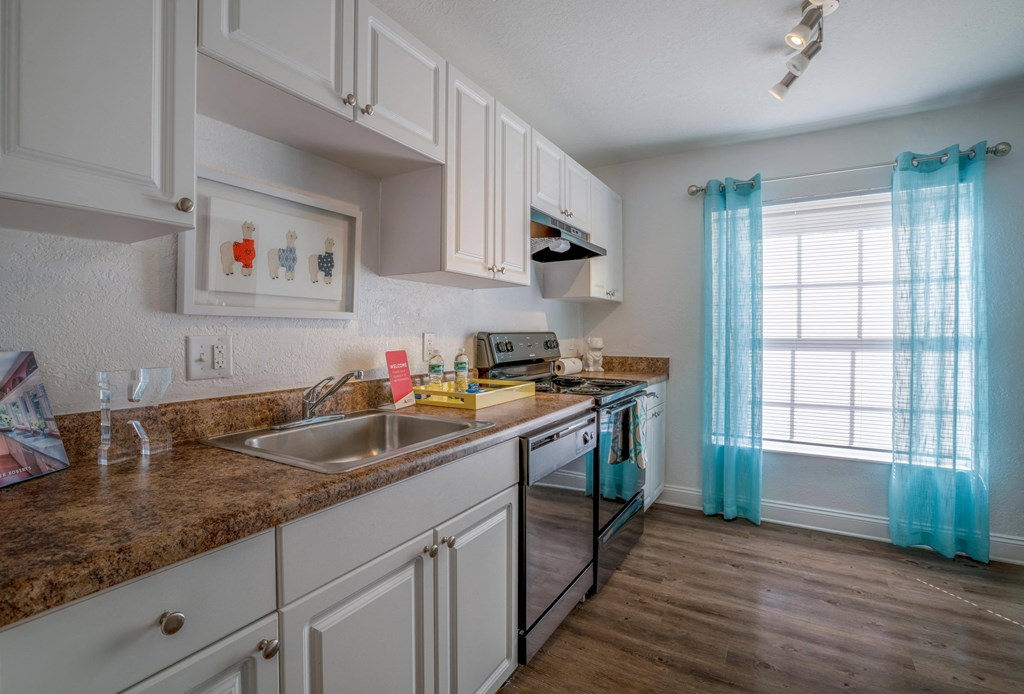 Tampa, FL Apartments – Belara Lakes – kitchen with white cabinets and hardwood flooring