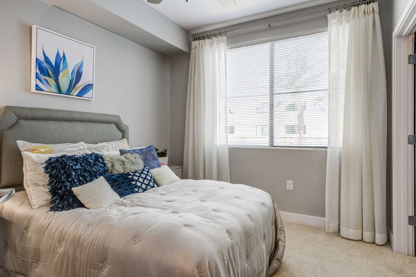 a bedroom with a bed and a large window