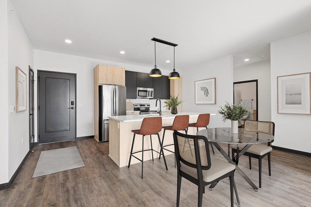 A modern kitchen with a dining table and chairs.