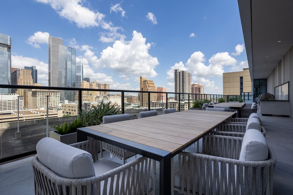 a long wooden table on a balcony overlooking the city
