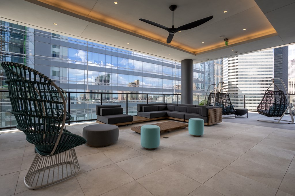 a lobby with couches and chairs in a building with tall windows