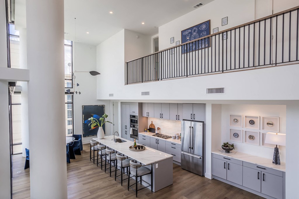 a kitchen with a white counter top and a long island with chairs
