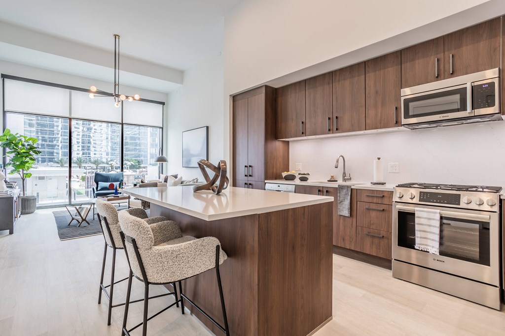 a kitchen and living room with a large island with stools