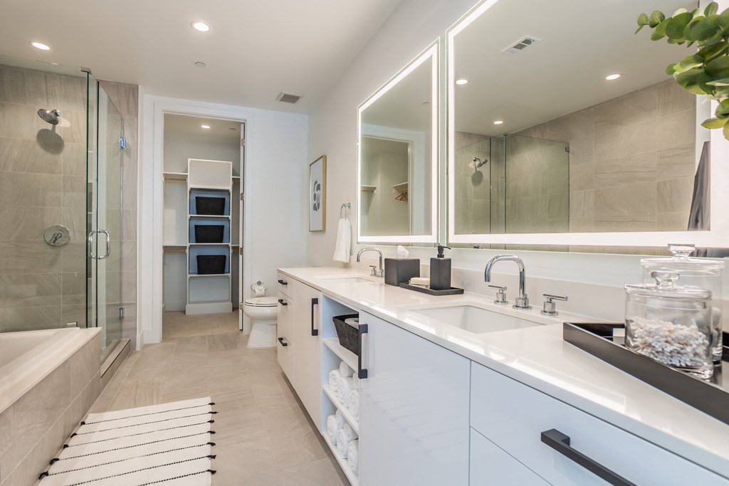 a bathroom with a sink and a shower and a mirror