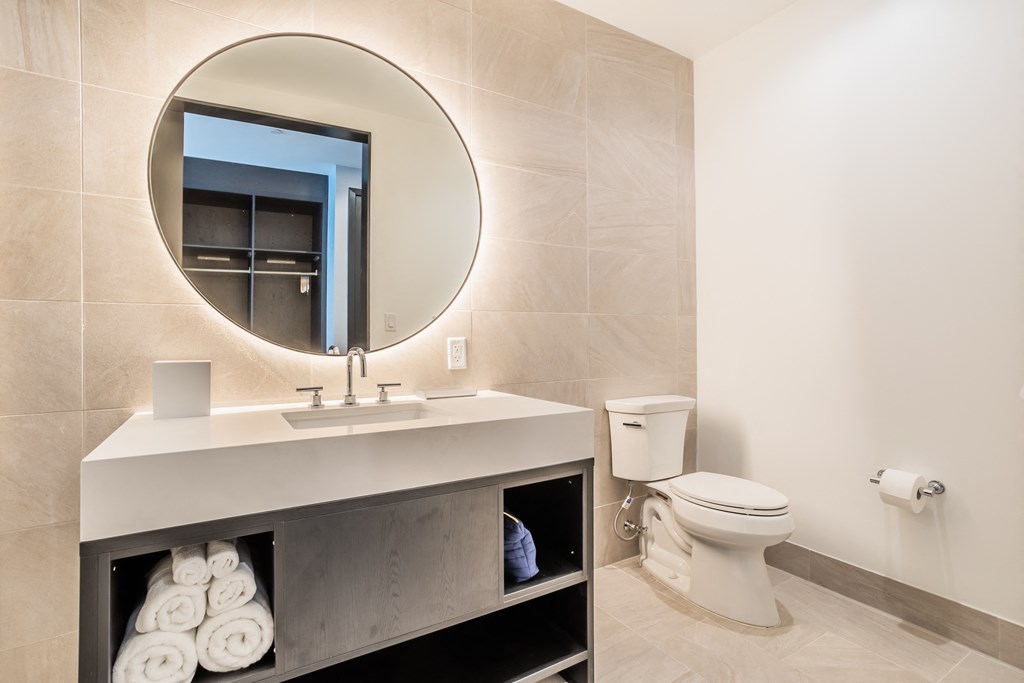 a bathroom with a mirror and a sink and a toilet