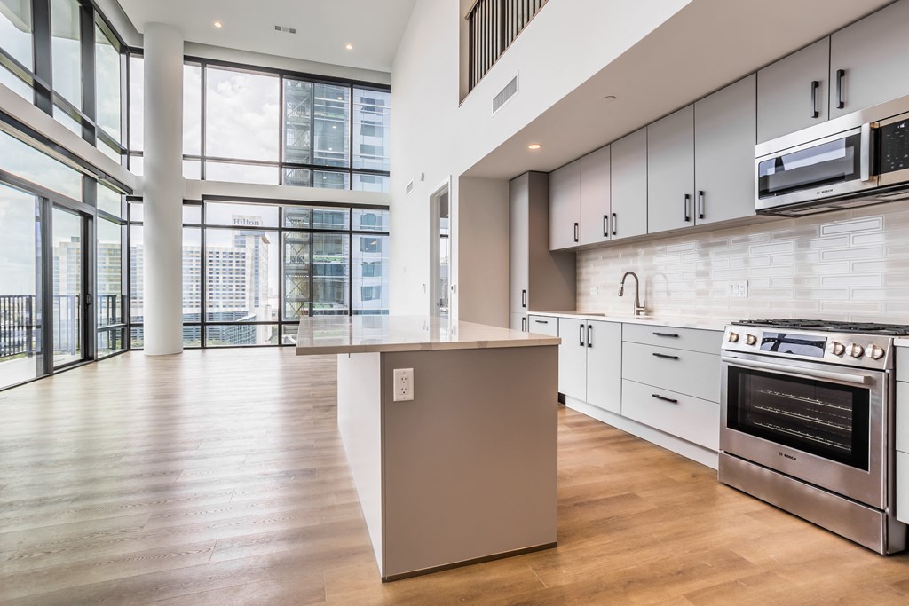 a large kitchen with white cabinets and stainless steel appliances