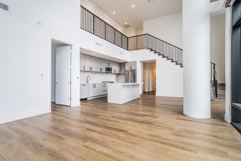 a living room with a kitchen and a staircase