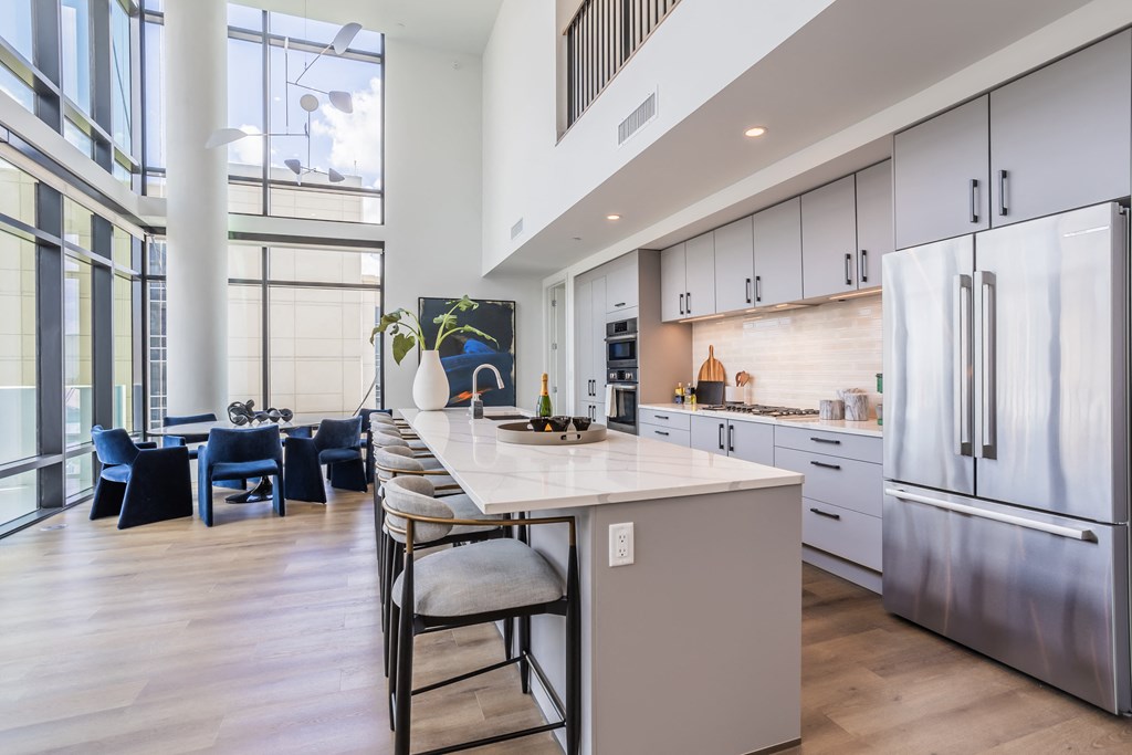 an open kitchen with a large island and stainless steel appliances