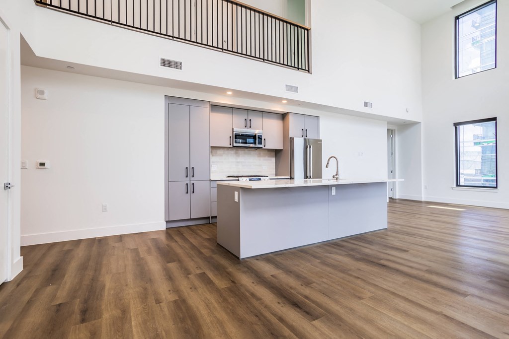 an empty living room and kitchen with a counter top and