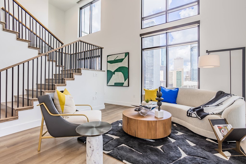 a living room with a couch and a chair and a staircase