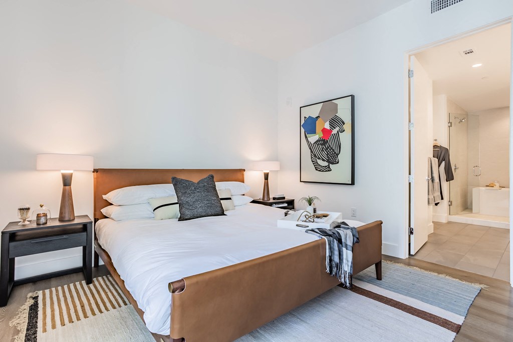 a bedroom with a large bed and a door to a bathroom