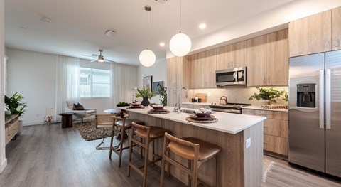 A modern kitchen with wooden cabinets and stainless steel appliances.