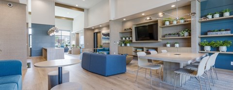 A modern living room with a blue couch and a white table.