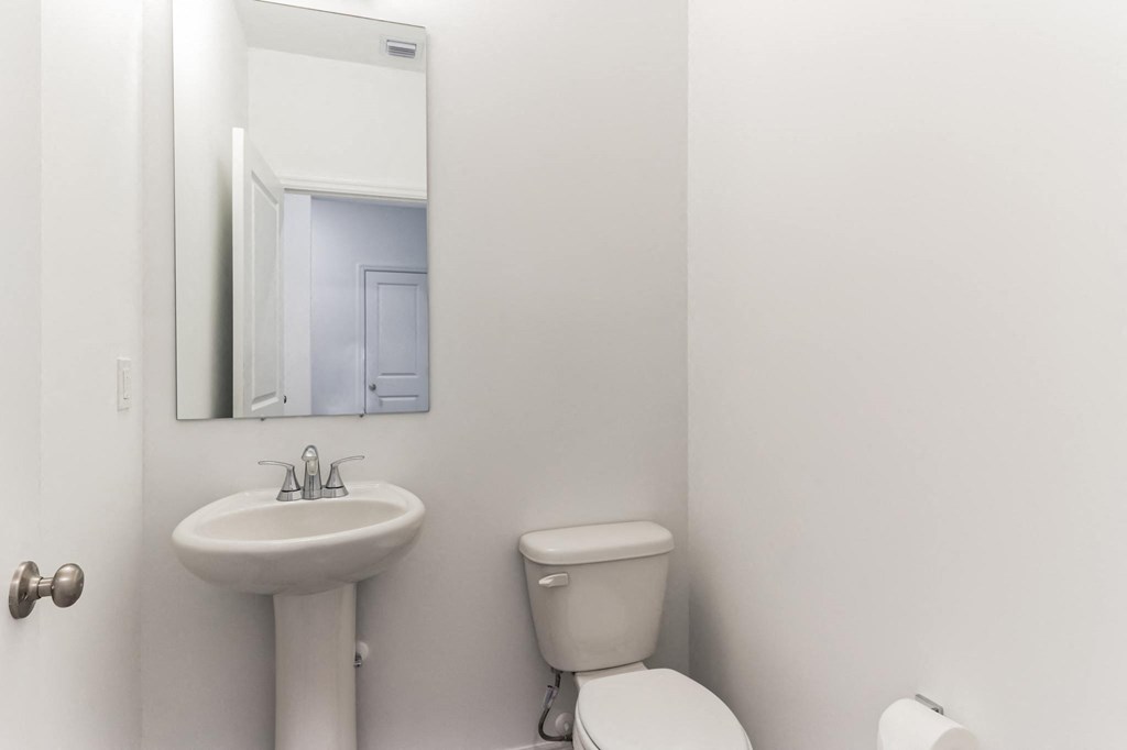 Boatman Hammock Townhomes in Lake Worth, FL photo of a bathroom with a sink toilet and a mirror