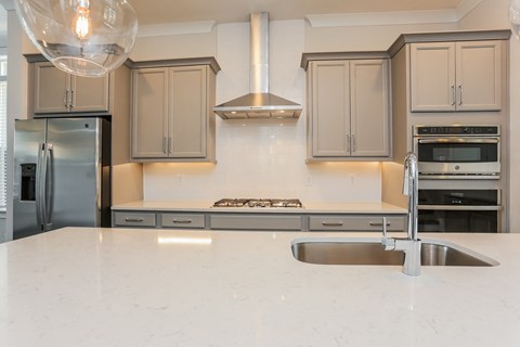 A modern kitchen with a stainless steel refrigerator and a white countertop.