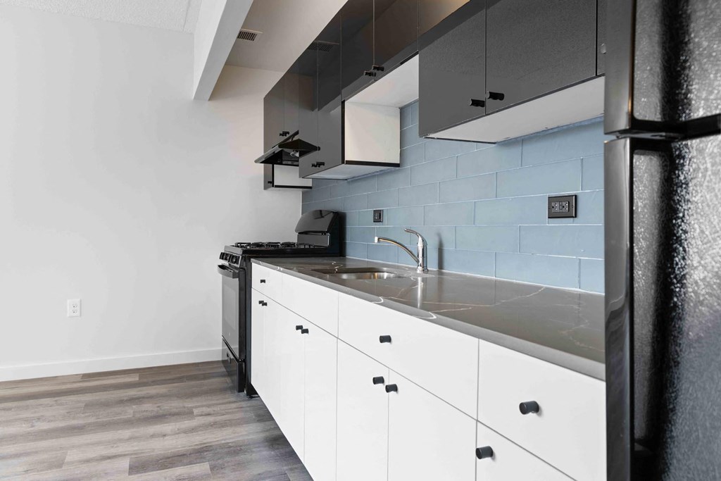 a kitchen with white cabinets and a stainless steel counter top