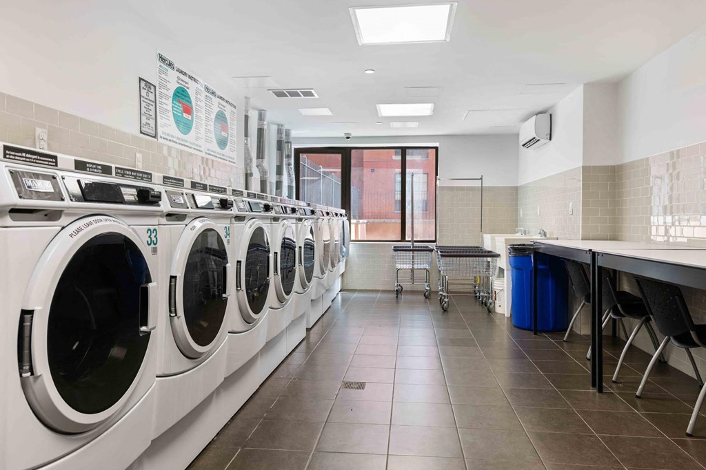 a laundry room with washers and dryers and a table with chairs