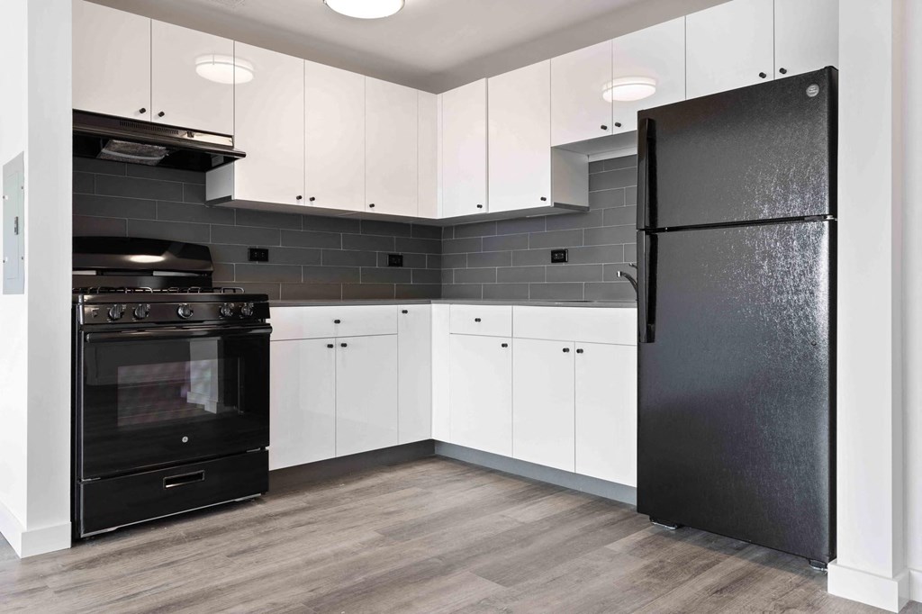 a kitchen with black appliances and white cabinets