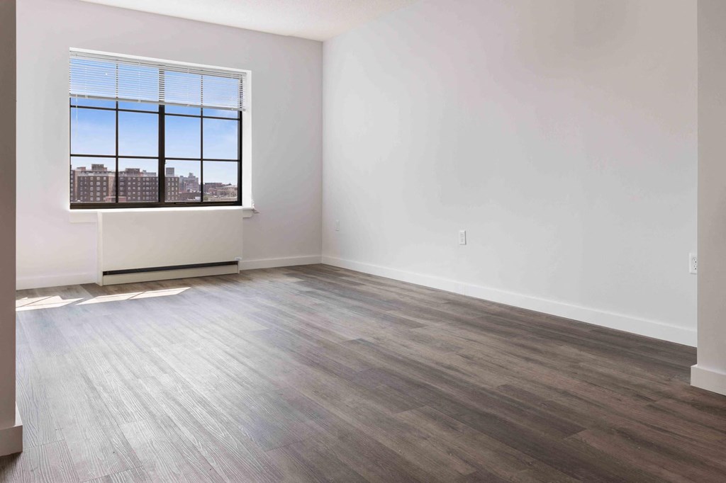an empty room with wood floors and a window
