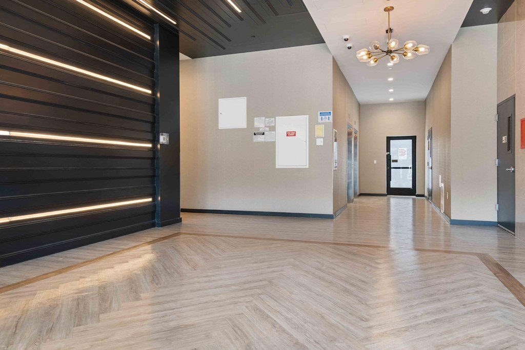 a hallway with a wooden floor and a black door