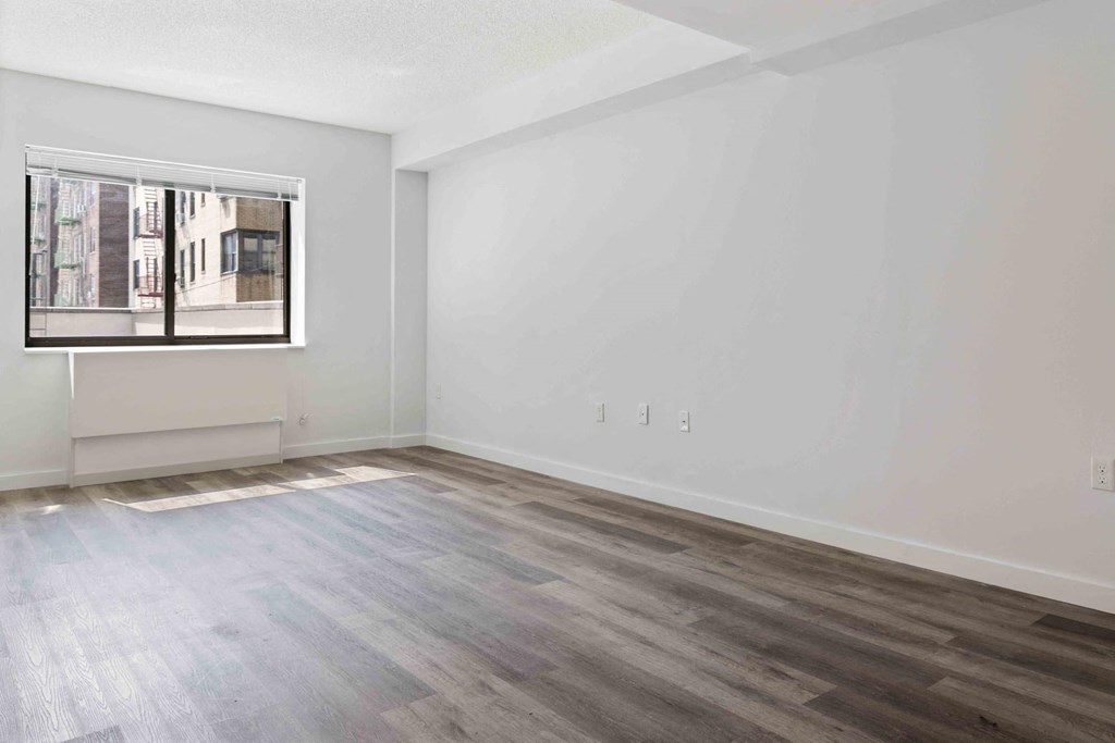 an empty room with white walls and a window