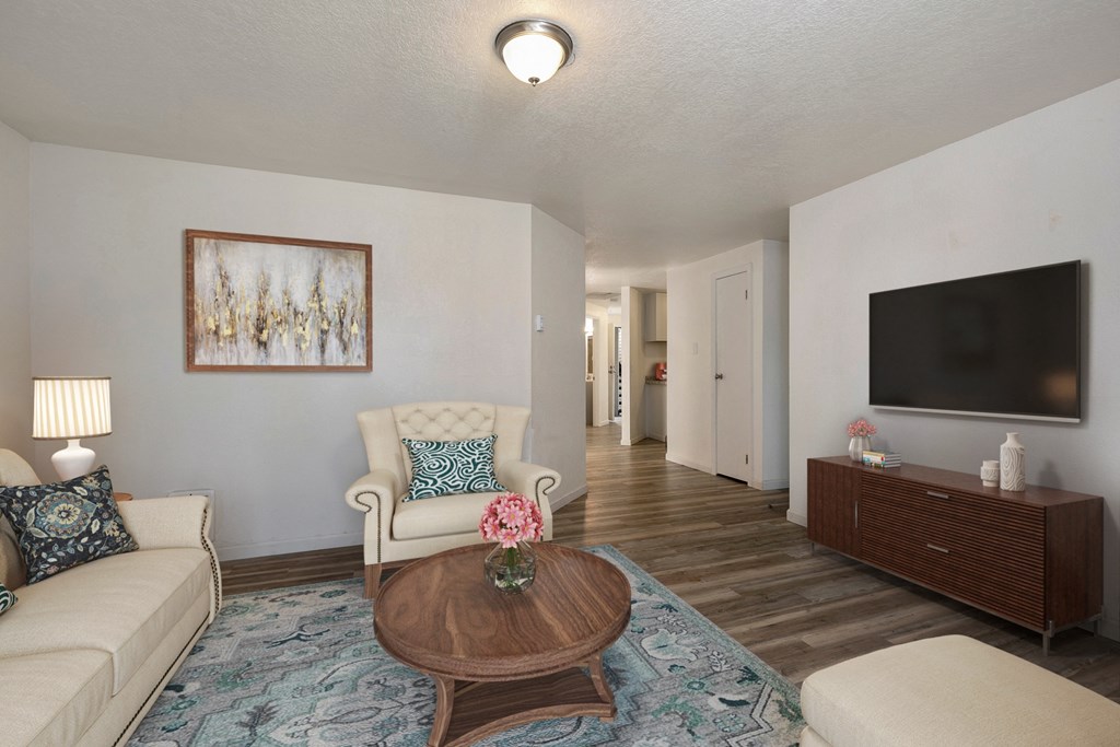 Apartments In Lynnwood For Rent - Evergreen Grove Apartments - Living Room With Comfortable Neutral Couch, Circle Wooden Coffee Table, And Ottoman