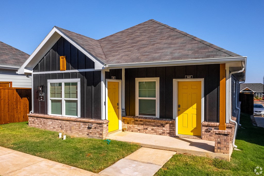 Fort Worth, TX Apartments - Cottages at Summer Creek - Exterior View Of House with Maintained Grass Lawn and Concrete Walkway