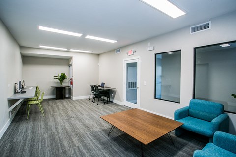 an office space with chairs and tables and a desk