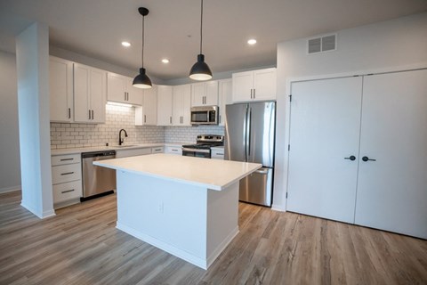 A kitchen with white cabinets and a wooden island.