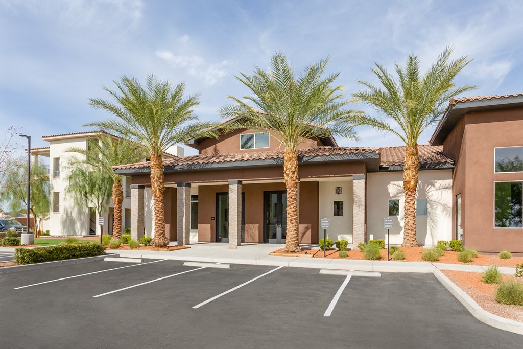 a parking lot in front of a building with palm trees