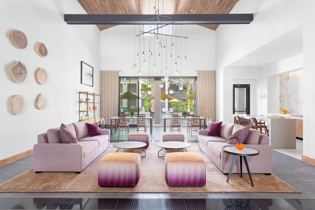 a living room with pink couches and a dining room with tables and chairs