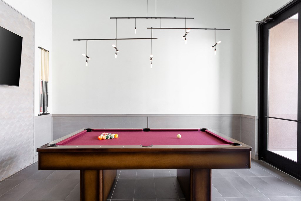 a billiards table in a game room with a pink pool table