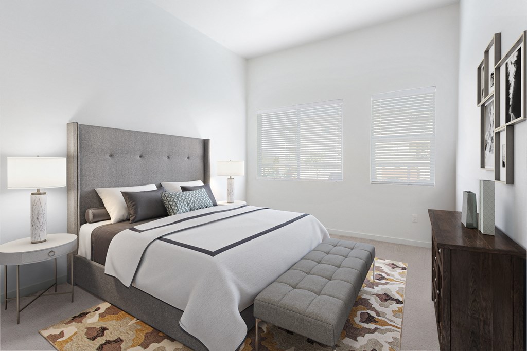 a bedroom with a large bed and two windows