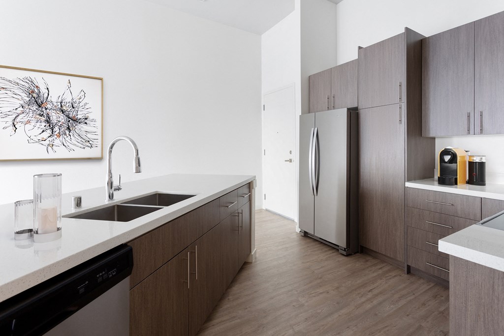 a kitchen with wooden cabinets and a stainless steel refrigerator