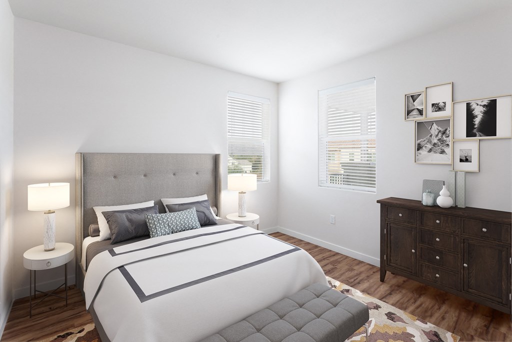 a bedroom with a large bed and two windows