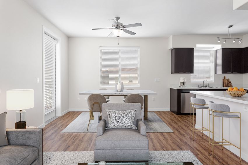 a living room with a couch and a chair and a kitchen with a table
