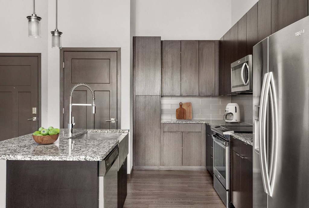a kitchen with stainless steel appliances and marble counter tops