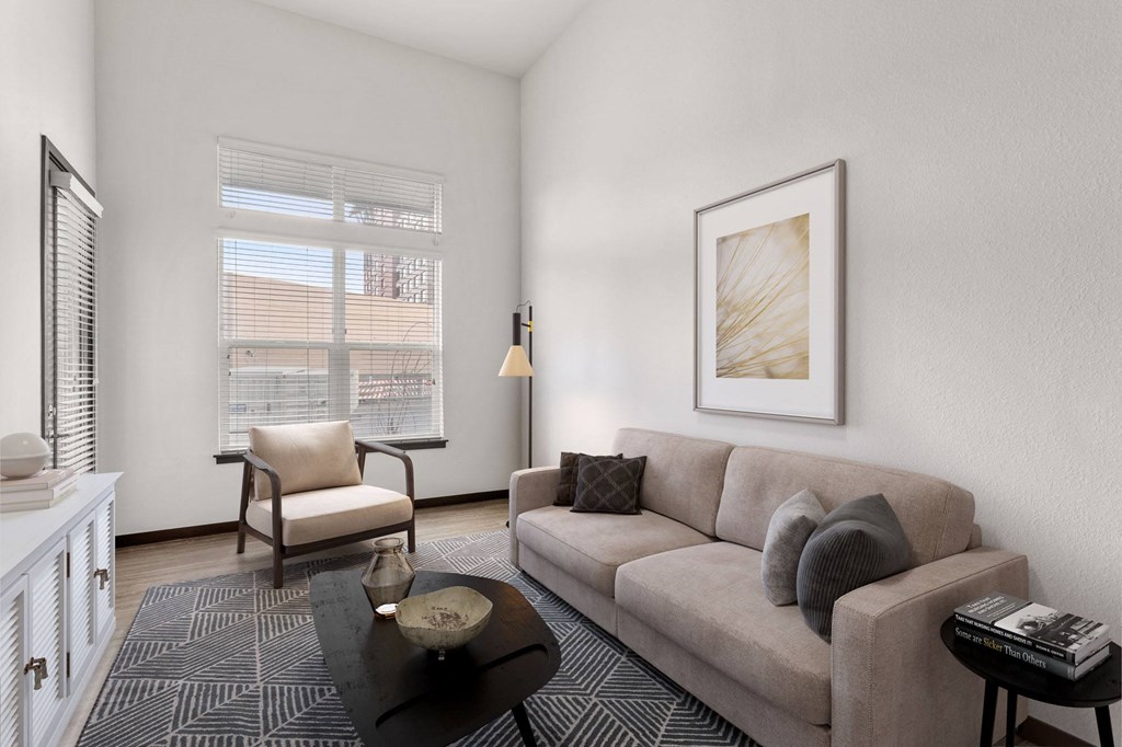 a living room with a couch and a chair and a window
