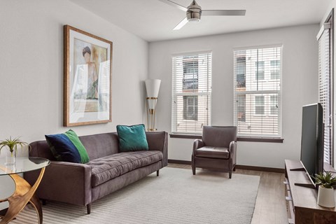 a living room with a couch and chairs and a tv