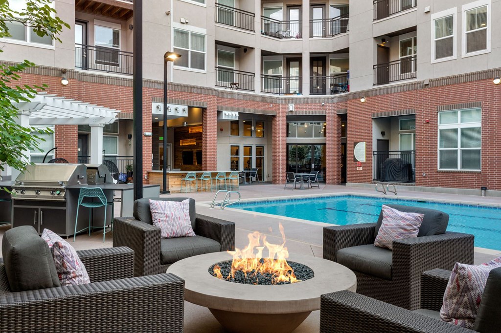 an outdoor patio with chairs and a fire pit