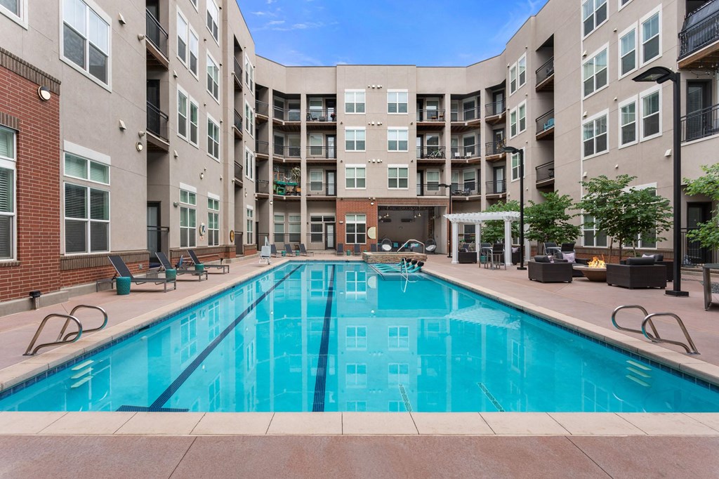 a swimming pool with an apartment building in the background