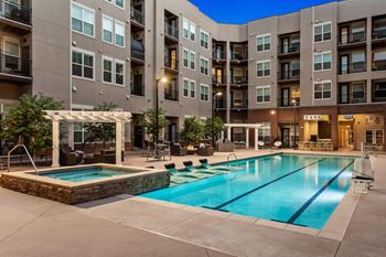 A large swimming pool in front of apartment buildings.