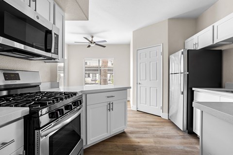 an open kitchen with white cabinets and stainless steel appliances