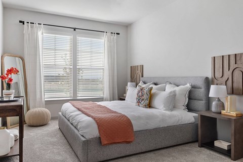 a bedroom with a bed and a large window