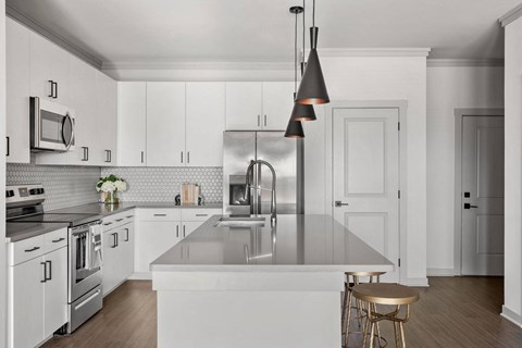 a kitchen with white cabinets and stainless steel appliances