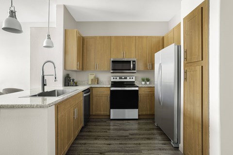 A modern kitchen with wooden cabinets and stainless steel appliances.