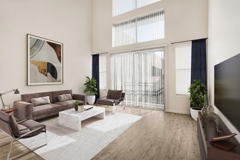 A modern living room with a brown sofa, a white coffee table, and a large painting on the wall.