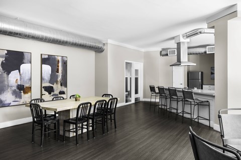 A dining room with a white table and black chairs.