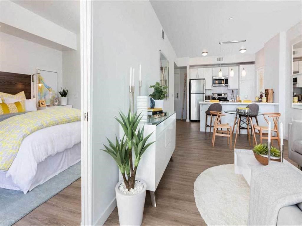 a bedroom with a bed and a living room with a kitchen